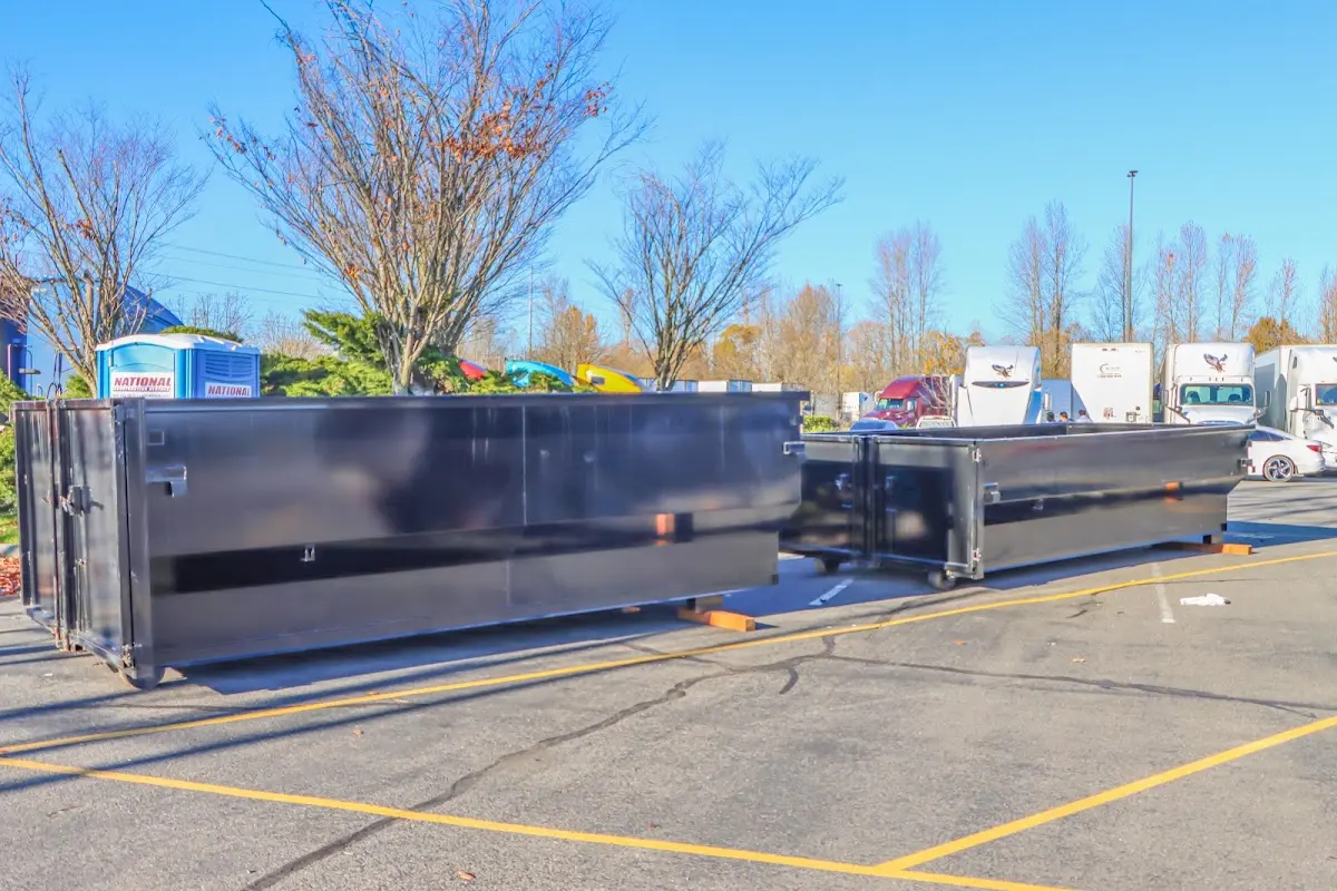 Professional dumpster rental service with roll-off container on residential driveway in Roxbury